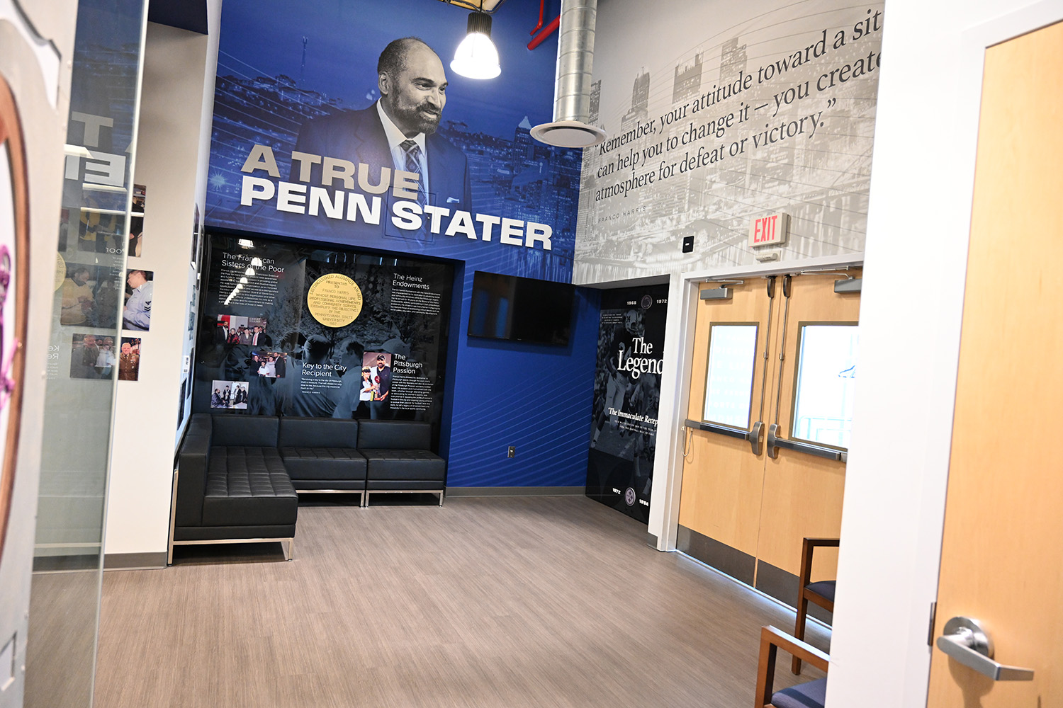 A lobby with tall ceilings and several tributes to Franco Harris on the walls.