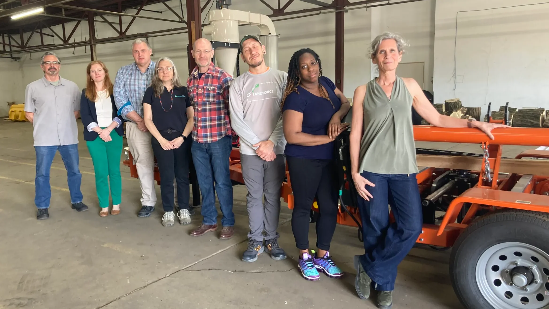 Landforce workers pose with a tractor