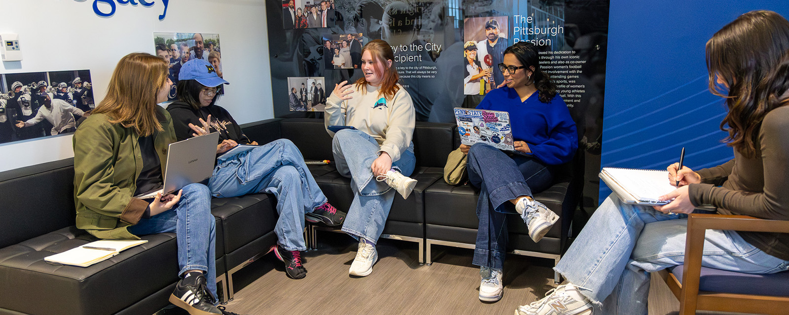 Students sit on a couch and have a discussion.