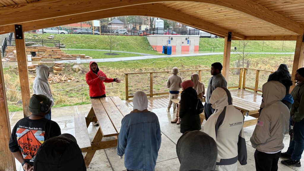 A Landforce representative speaks to a group of people under a pavilion