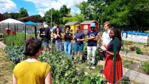 A group of students listen to instructions in an urban garden