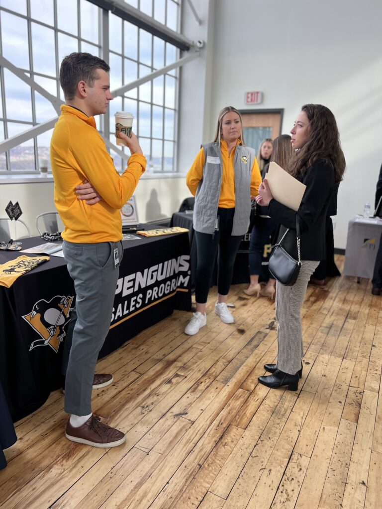 Pittsburgh Penguins representatives talking to student