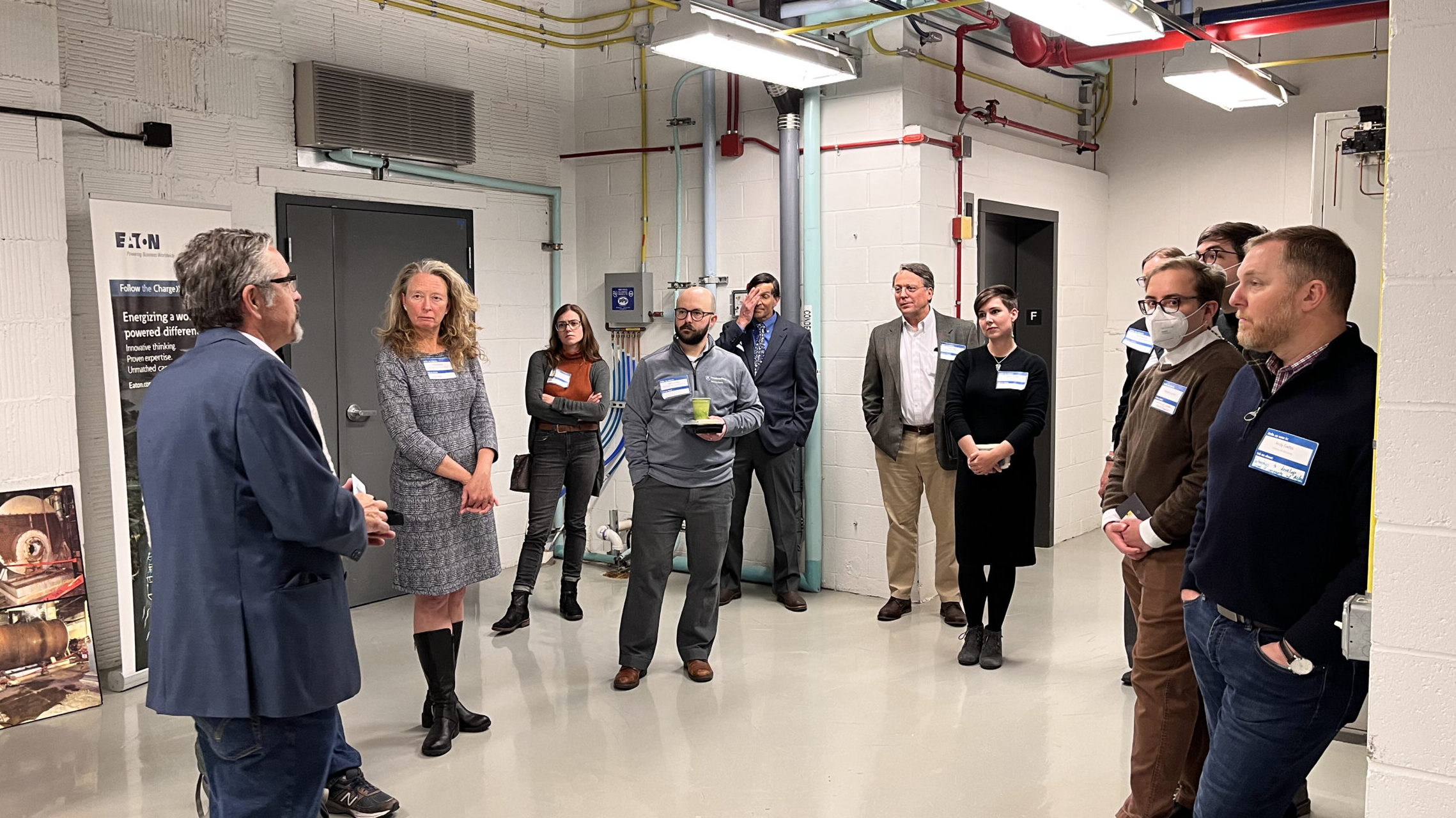 a group of people take part in a tour of an industrial building