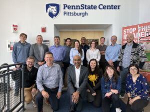 Nittany AI group posing in front of the Penn State Center Pittsburgh sign