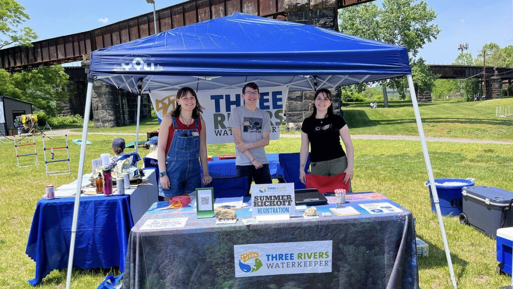 Jacob Levendosky and two others stand at a Three Rivers Waterkeeper booth.