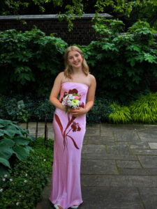 Lucy standing in dress with flowers