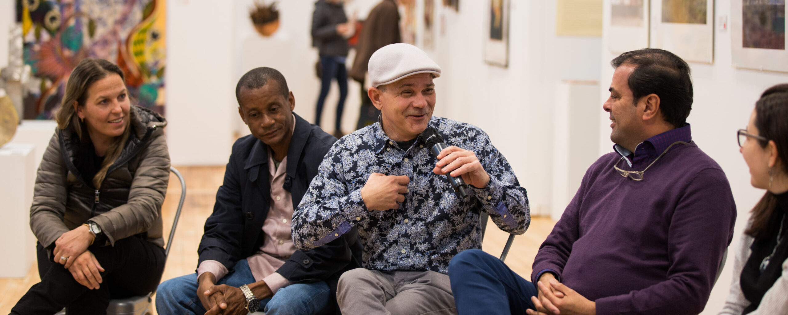 group of people sitting and talking at art exhibit