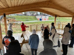 Landforce team members stand under a pavilion and listen to a speaker during the National Green Infrastructure Certification Program.