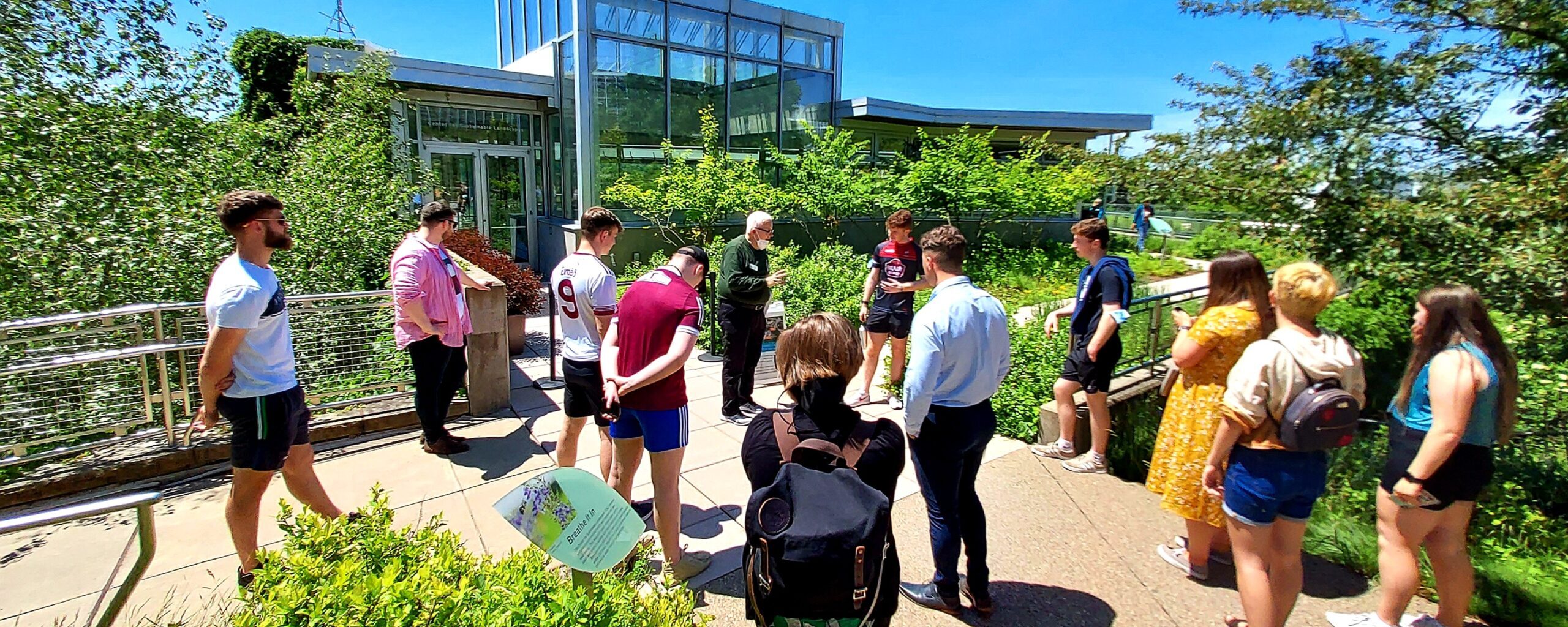 Instructor with a group of students outside in front of a high performance building