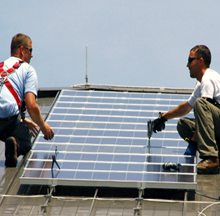 Two men installing a rooftop solar panel