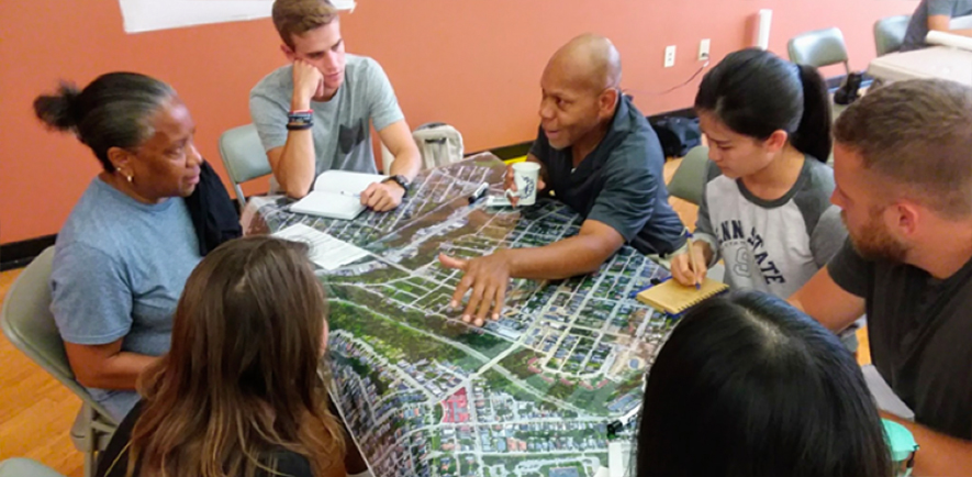 Student interns surrounding a community planning map